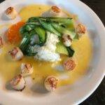 Plate of sea scallops, jasmine rice, asian greens, orange slices, and orange sauce