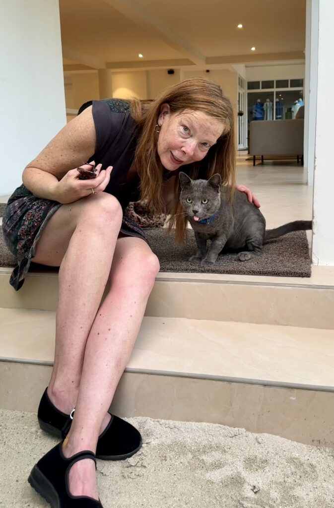 woman sitting on steps with grey cat